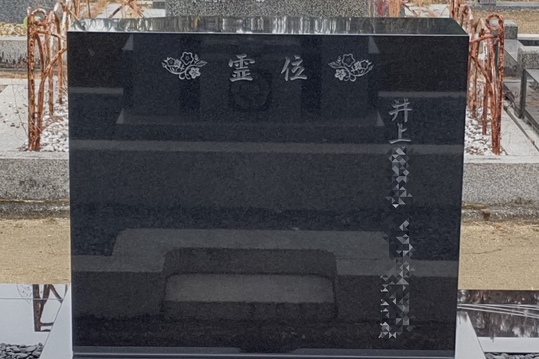 墓石背面の表題の左右に桜の模様を彫刻